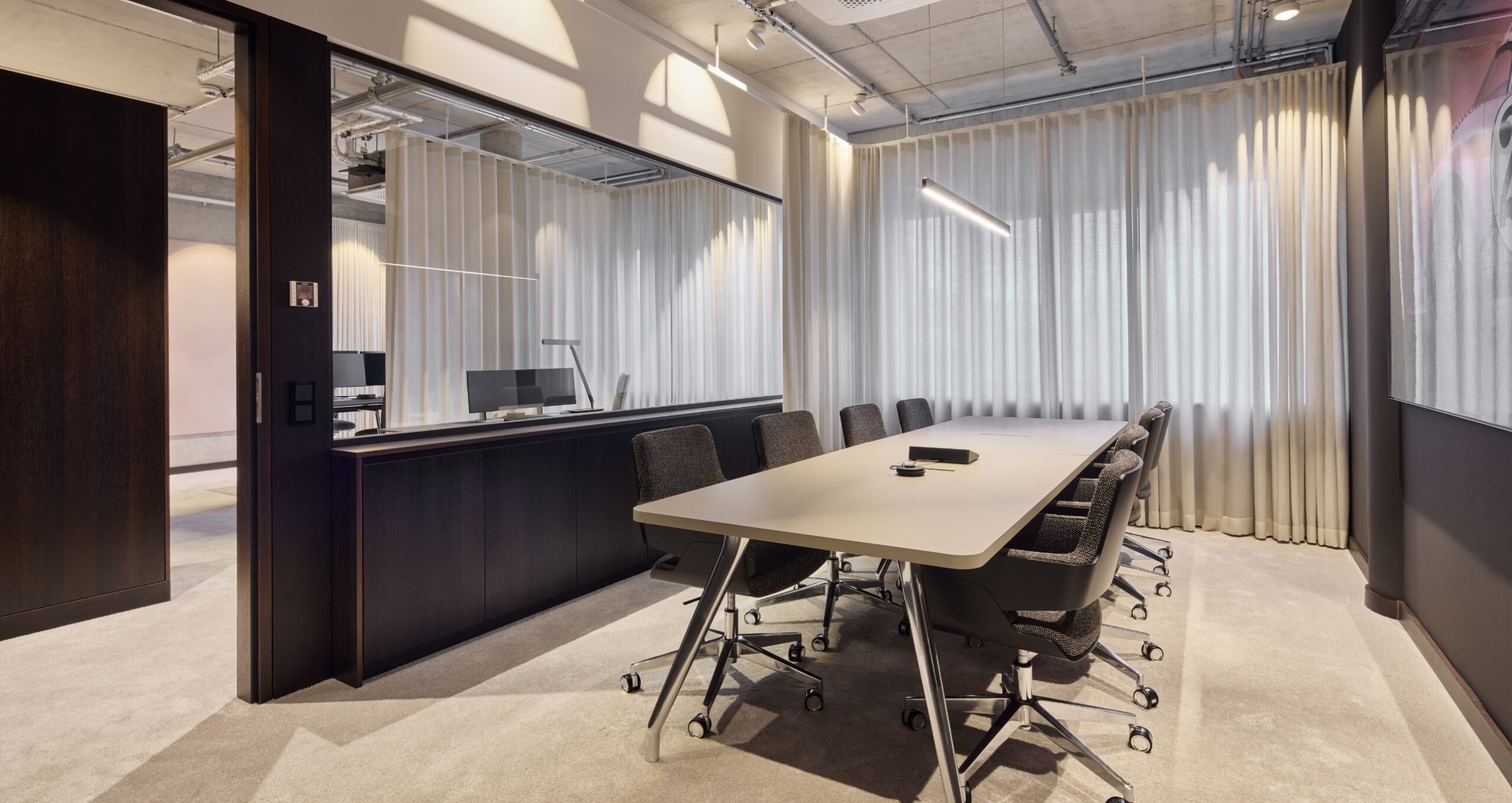 nmp-ventures-meetingbereich-glassystemwand Arbeitsplatz mit hochwertiger Möblierung und klarer Raumstruktur in der Motorworld München.