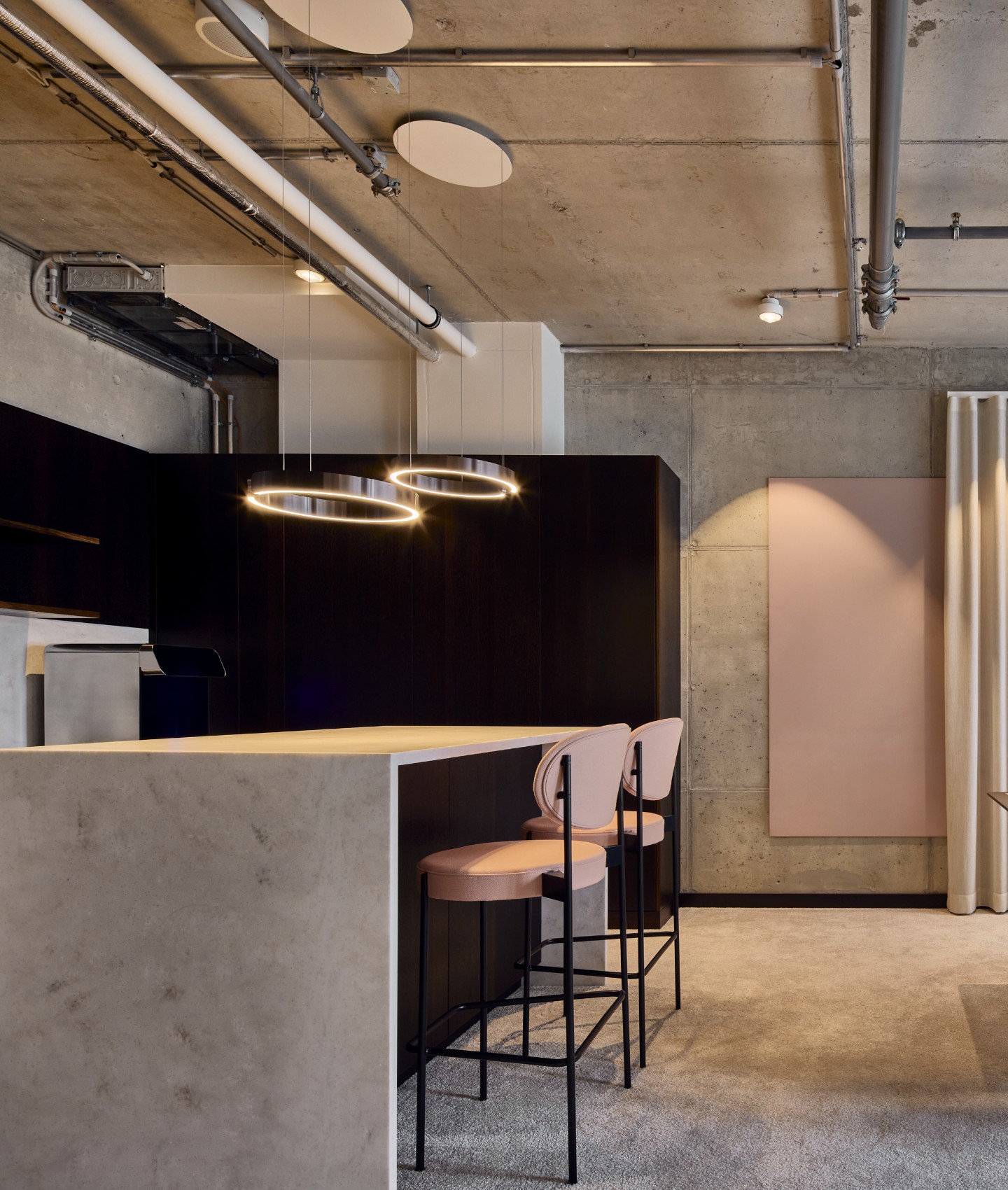 nmp-ventures-sichtbeton-industriearchitektur-buero Sichtbetonwände und offene Deckeninstallationen prägen die industrielle Architektur im Büro von NMP Ventures in der Motorworld München.